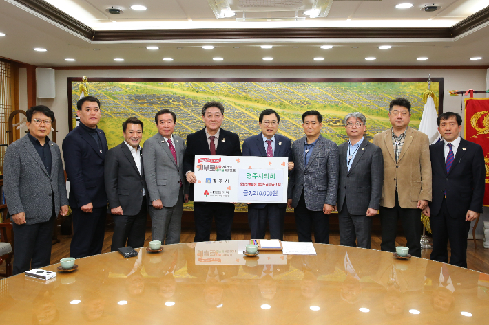 이동협 경주시의회 의장이 주낙영 시장에게 영남권 산불 피해 복구를 돕기 위한 성금 721만 원을 전달하고 있다. 경주시 제공