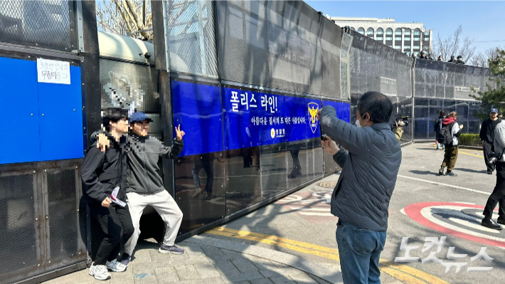 파손된 경찰버스 앞에서 인증사진을 찍는 윤 전 대통령 지지자들. 박인 기자