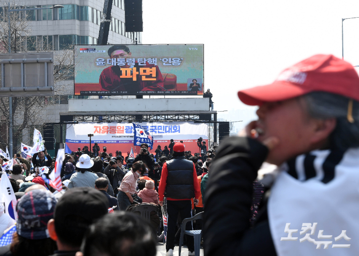 4일 오전 서울 한남동 대통령 관저 인근에서 윤석열 대통령 지지자들이 헌법재판소의 윤 대통령 파면 관련 중계영상을 시청하고 있다. 황진환 기자