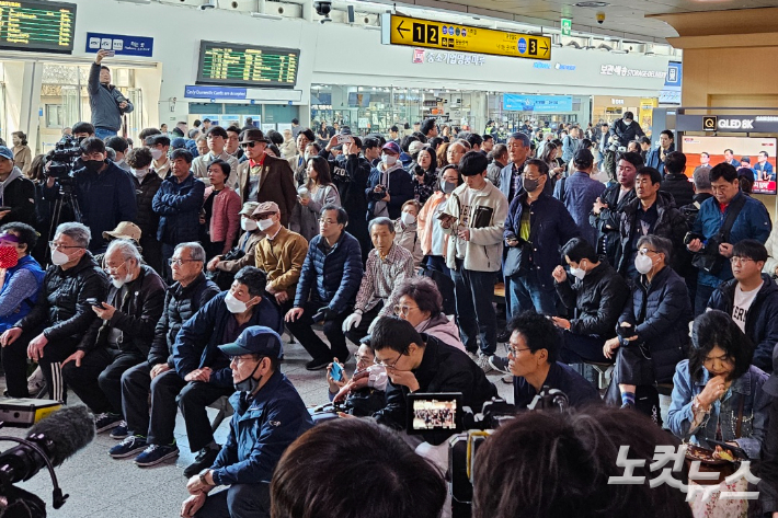 서울역에서 탄핵 심판 선고 생중계를 시청하고 있는 시민들. 