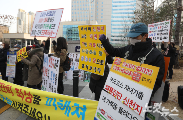 전국신천지피해자연대 관계자들이 손 피켓을 들고 있다. 이한형 기자