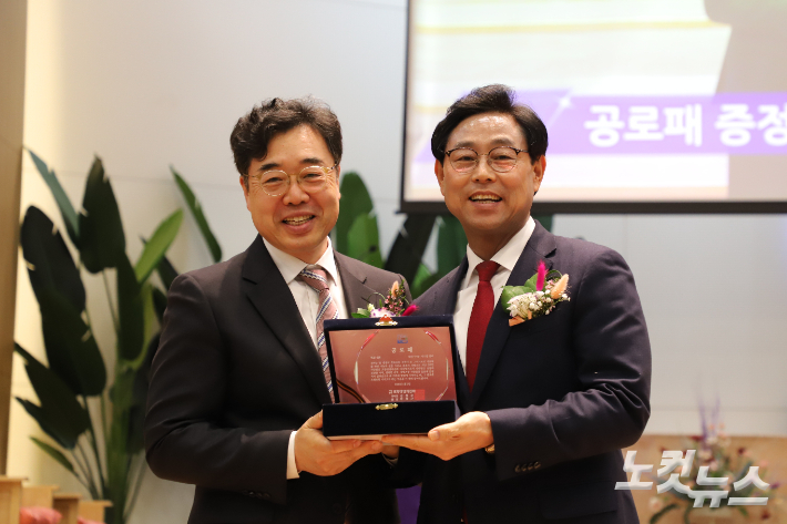 김정규 신임이사장(좌)이 이수현 직원이사장(우)에게 공로패를 전달했다. 유상원 아나운서