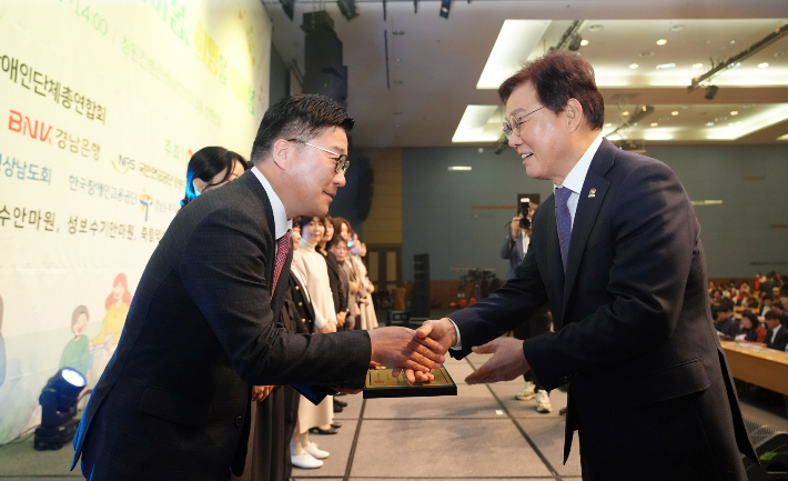 BNK경남은행 허종구 부행장이 14일 유공자 포상식 무대에 올라 박완수 지사로부터 유공자 표창을 받고 있다. BNK경남은행 제공