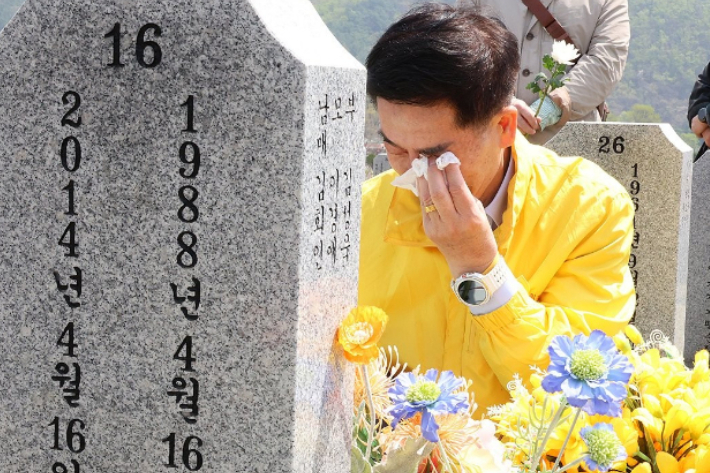 16일 오전 국립대전현충원에서 열린 세월호 참사 11주기 순직교사·소방관·의사자 기억식에서 순직교사 故 김초원 씨의 아버지 김성욱 씨가 묘역에 헌화하고 있다. 연합뉴스