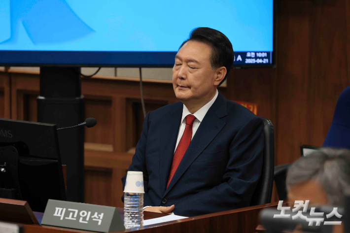 윤석열 전 대통령이 21일 서초동 서울중앙지법에서 열린 내란 우두머리 혐의에 대한 두 번째 정식 재판에 출석하고 있다. 사진공동취재단