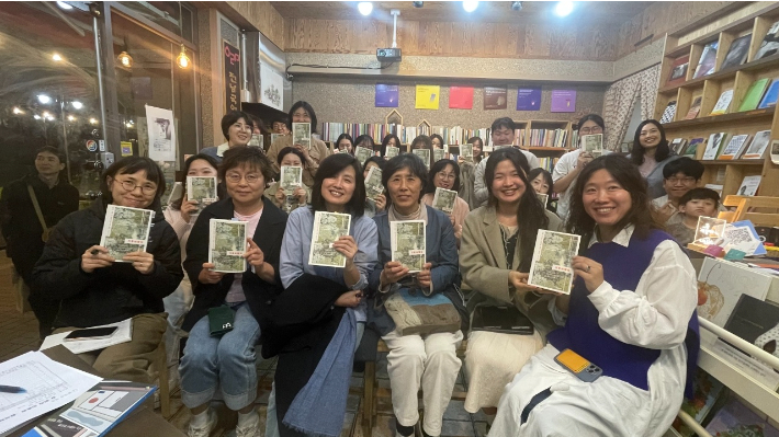 임영신 작가(왼쪽에서 세 번째)와 참석자들이 북토크를 마친 뒤 '기후여행자'를 함께 들고 기념촬영을 하고 있다. '서성이다' 제공 