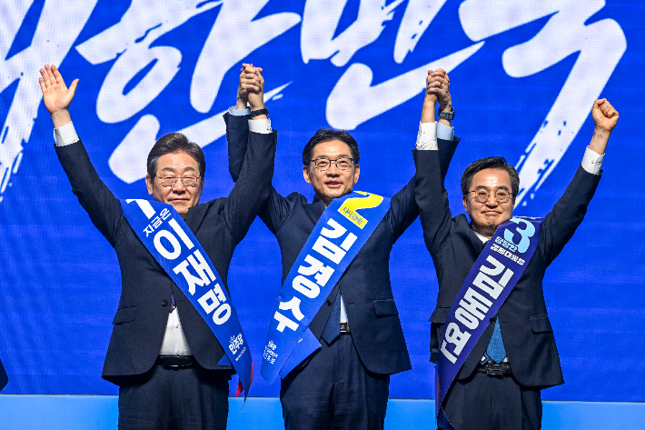  이재명(왼쪽부터), 김경수, 김동연 더불어민주당 대선 경선 후보가 26일 광주 서구 김대중컨벤션센터에서 열린 '제21대 대통령선거 후보자 선출을 위한 호남권 합동연설회'에서 함께 손을 들어 인사하고 있다. 연합뉴스