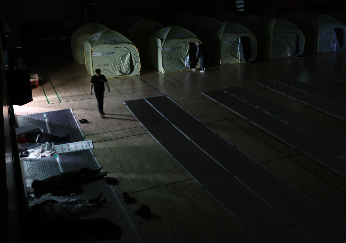 27일 강원 인제군 기린실내체육관에 마련된 산불 대피소에서 밤을 보낸 주민들이 발걸음을 옮기고 있다. 연합뉴스 