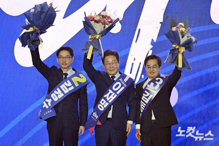 더불어민주당 제21대 대통령선거 후보로 선출된 이재명 후보가 27일 경기도 고양 킨텍스에서 열린 수도권·강원·제주 합동연설회에서 함께 경선을 벌인 김동연-김경수 후보와 무대에 올라 함께 손을 들어보이고 있다.