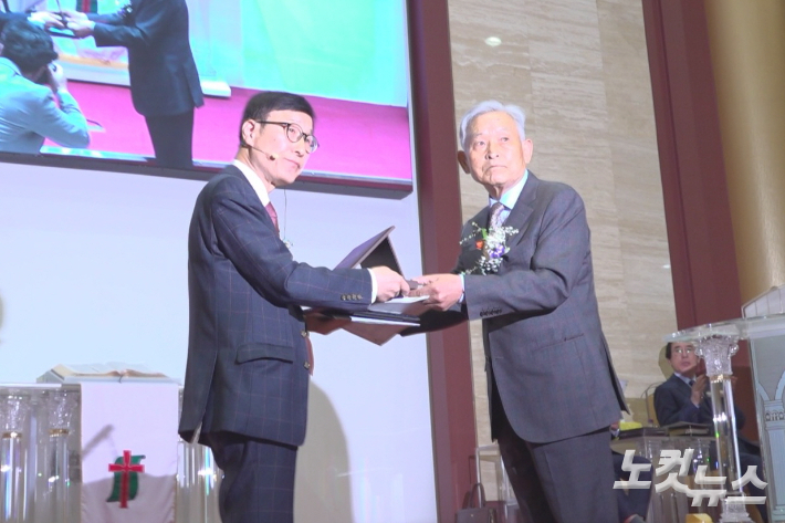 건축위원장 김명용 장로(우)가 주명갑 담임목사(좌)에게 열쇠를 전달하고 있다. 유상원 아나운서