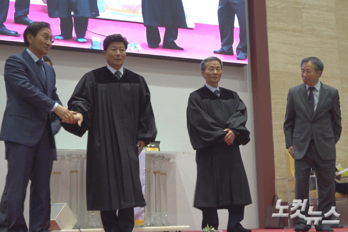 이상용 장로(좌측 두 번째)와 김정석 장로(좌측 세 번째)가 가운을 입은 뒤 인사하고 있다. 유상원 아나운서