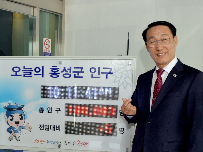 이용록 홍성군수가 '인구 10만'이 회복된 홍성군 인구현황판 앞에서 감사의 뜻을 표하고 있다. 홍성군 제공