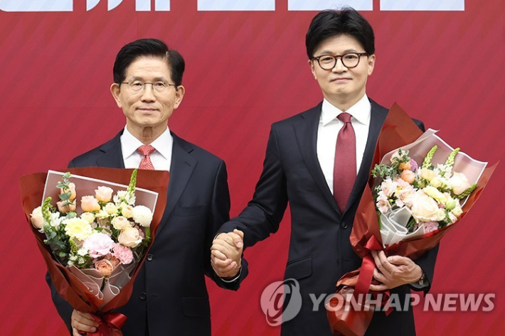 (서울=연합뉴스) 국민의힘 대선 최종 경선에 진출한 김문수(왼쪽)·한동훈 후보가 29일 서울 여의도 당사에서 2차 경선 결과 발표 후 꽃다발을 들고서 기념촬영 하고 있다. 2025.4.29 [국회사진기자단] utzza@yna.co.kr 연합뉴스