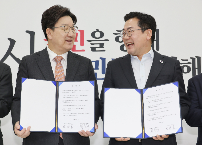 1일 서울 여의도 국회에서 더불어민주당 박찬대 당대표 직무대행 겸 원내대표(오른쪽)와 국민의힘 권성동 원내대표가 추경안 합의문에 서명한 뒤 미소짓고 있는 모습. 연합뉴스