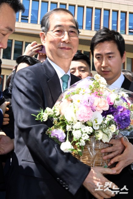 한덕수 전 국무총리가 2일 서울 여의도 국회 소통관에서 제21대 대통령 선거 출마선언 기자회견을 마치고 이동하며 지지자로부터 꽃다발을 전달받고 있다.