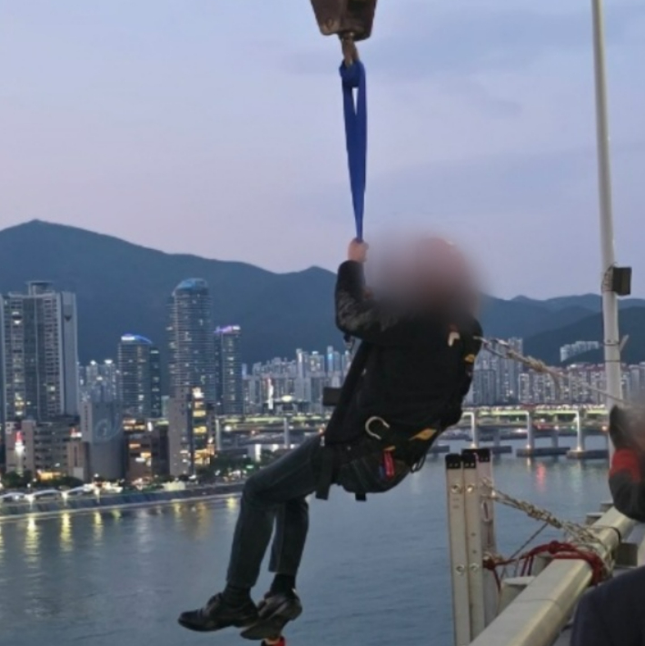 11일 부산 광안대교에서 고공 농성을 벌인 형제복지원 피해 생존자 최승우씨가 8시간 만에 구조되고 있다. 부산경찰청 제공 