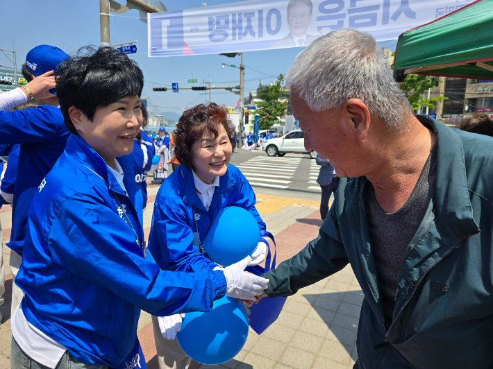 왼쪽부터 서선란·이영란 순천시의원이 아랫장 출정식에서 밝은 표정으로 시민과 악수하고 있다. 고영호 기자