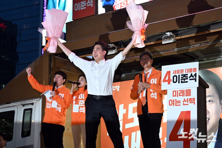 개혁신당 이준석 대선후보가 12일 서울 중구 청계광장에서 가진 서울 첫 집중유세에서 유세차에 올라 꽃다발을 들어보이고 있다.