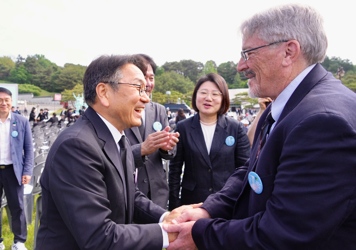 강기정 광주광역시장이 18일 오전 국립5·18민주묘지에서 열린 '제45주년 5·18민주화운동 기념식'에서 5·18민주화운동 당시 시민군으로 참여한 미국인 '데이비드 돌린저(David Lee Dolinger, 한국명 임대운)'씨와 만나 인사를 나누고 있다. 광주광역시 제공  