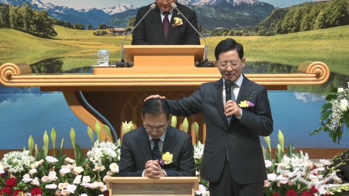 최선길 원로목사가 7대 담임으로 부임한 최규완목사를 위해 안수기도 하는 모습. 최진성 아나운서