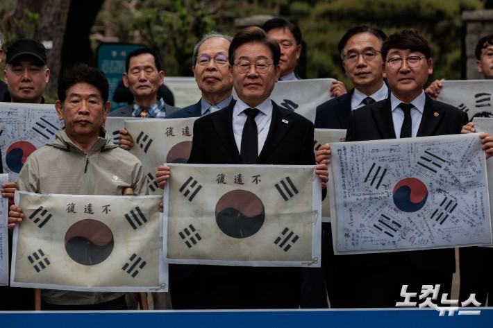 이재명 더불어민주당 후보가 19일 오전 서울 용산구 김구 묘역에서 참배를 앞두고 이 후보 지지선언을 한 독립운동가 후손들과 기념촬영을 하고 있다.