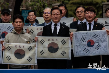 이재명 더불어민주당 후보가 19일 오전 서울 용산구 김구 묘역에서 참배를 앞두고 이 후보 지지선언을 한 독립운동가 후손들과 기념촬영을 하고 있다.