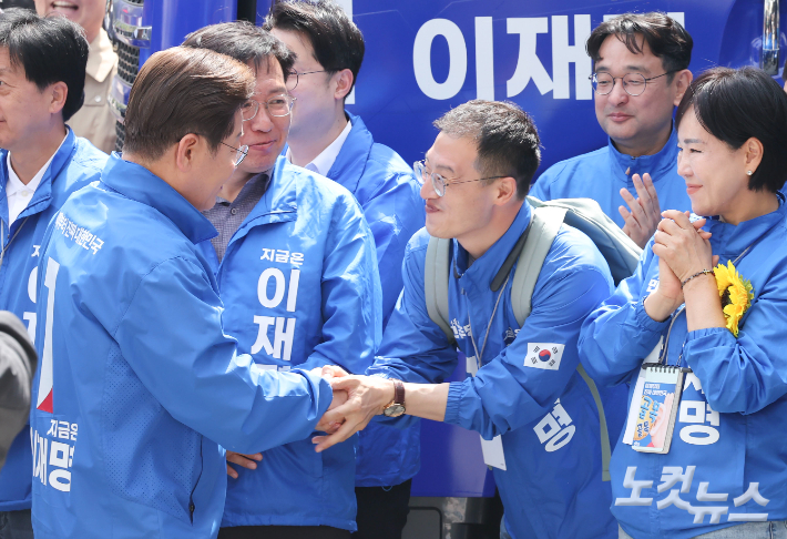 이재명 더불어민주당 대선 후보가 19일 서울 용산역 광장에서 열린 집중유세에 참석하며 이날 민주당에 입당한 김상욱 의원과 인사하고 있다. 류영주 기자