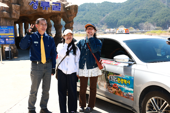 울진을 찾은 관광객들이 관광택시를 타고 성류굴을 방문한 뒤 기념사진을 촬영하고 있다. 울진군 제공
