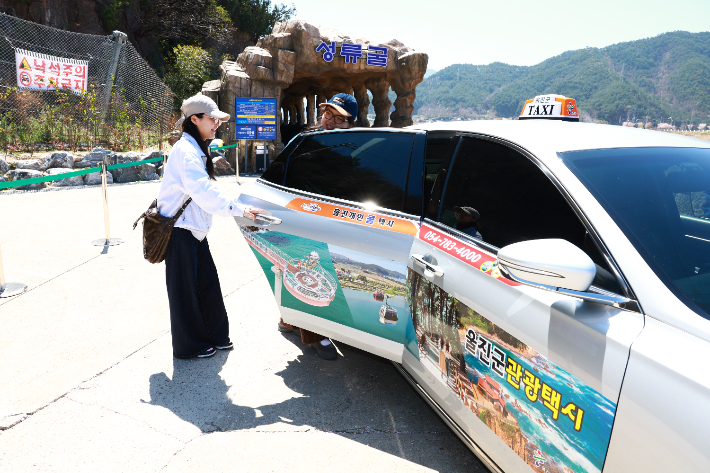 울진을 찾은 관광객들이 관광택시를 타고 성류굴을 방문한 뒤 기념사진을 촬영하고 있다. 울진군 제공