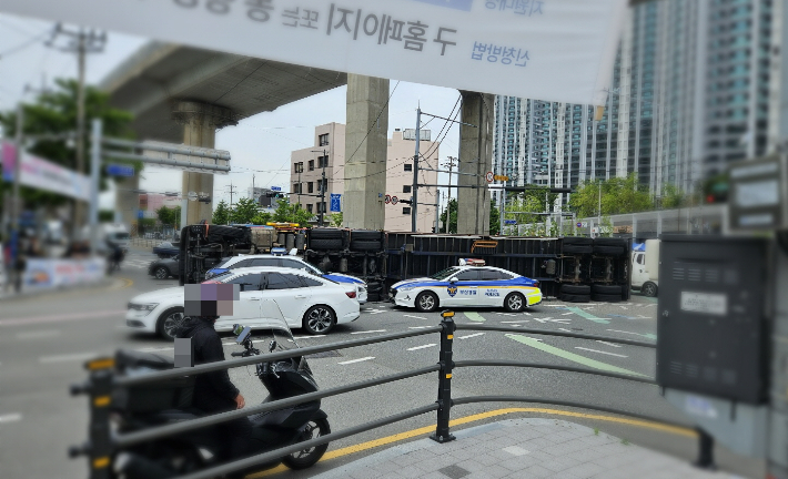 21일 오전 11시 50분쯤 부산 사상구 주례교차로에서 화물 트레일러가 전도돼 일대 교통이 통제됐다. 부산경찰청 제공