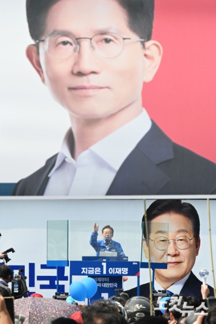 이재명 더불어민주당 대선 후보가 21일 인천 부평구 부평역 북광장에서 열린 집중 유세에 참석해 지지를 호소하고 있는 가운데 김문수 국민의힘 대선 후보의 현수막이 보이고 있다.