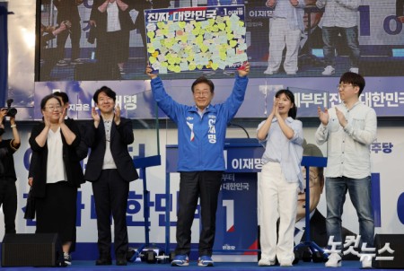 이재명 더불어민주당 대선 후보가 21일 오후 인천광역시 계양구 계양역 앞 광장에서 유세를 하기 전 시민들이 적은 소망 쪽지가 붙은 액자를 받고 있다.