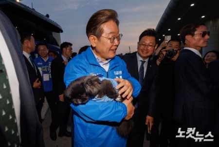 이재명 더불어민주당 대선후보가 21일 오후 인천 계양역 유세를 마치고 떠나던 중 한 지지자의 강아지를 안아보고 있다.