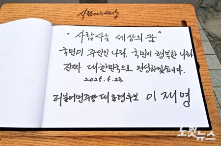 이재명 더불어민주당 대선 후보가 23일 오전 김해시 봉하마을 고 노무현 전 대통령 묘역을 찾아 참배를 마친 뒤 방명록 작성을 하고 있다.