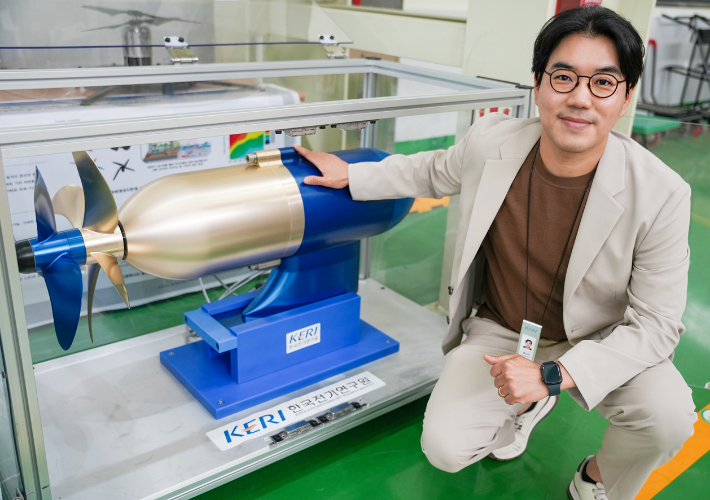 KERI 홍도관 박사가 '50kW급 비접촉 마그네틱 기어 적용 상반회전 프로펠러' 옆에 있다. 한국전기연구원 제공 