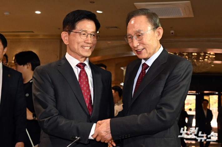 김문수 국민의힘 대통령 후보와 이명박 전 대통령이 27일 서울 여의도의 한 호텔에서 오찬을 위해 만나며 악수를 하고 있다.