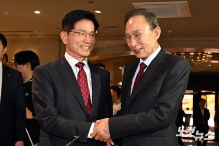 김문수 국민의힘 대통령 후보와 이명박 전 대통령이 27일 서울 여의도의 한 호텔에서 오찬을 위해 만나며 악수를 하고 있다.