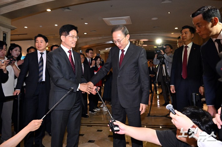 김문수 국민의힘 대통령 후보와 이명박 전 대통령이 27일 서울 여의도의 한 호텔에서 오찬을 위해 만나며 악수를 하고 있다.