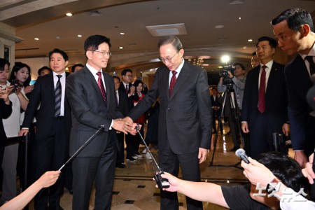 김문수 국민의힘 대통령 후보와 이명박 전 대통령이 27일 서울 여의도의 한 호텔에서 오찬을 위해 만나며 악수를 하고 있다.