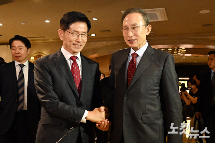 김문수 국민의힘 대통령 후보와 이명박 전 대통령이 27일 서울 여의도의 한 호텔에서 오찬을 위해 만나며 악수를 하고 있다. 윤창원 기자