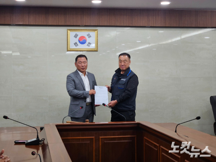 28일 (왼쪽부터) 부산버스조합 성현도 이사장과 부산버스노조 박성훈 위원장이 합의안을 들고 카메라를 향해 미소 짓고 있다. 김혜민 기자 