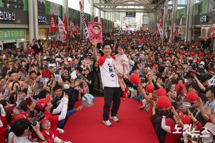 김문수 국민의힘 대선후보가 28일 경북 경산시 경산공설시장에서 어린이를 안고 시민들에게 인사하고 있다.