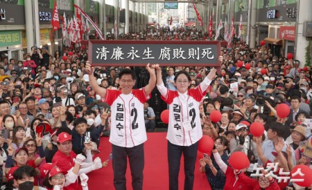 김문수 국민의힘 대선후보가 28일 경북 경산시 경산공설시장에서 청렴영생 부패즉사라고 쓴 액자를 들고 시민들에게 인사하고 있다.