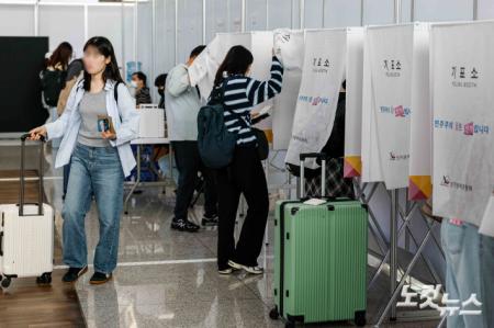 제21대 대통령선거 사전투표가 시작된 29일 인천국제공항 제1여객터미널에 마련된 사전투표소를 찾은 여행객들이 출국에 앞서 투표 하고 있다.