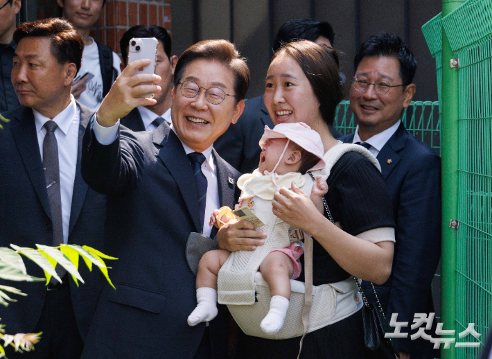 이재명 더불어민주당 후보가 29일 서울 서대문구 신촌동 주민센터에서 제 21대 대통령선거 사전투표를 마치고 주민과 기념 촬영을 하고 있다. 박종민 기자