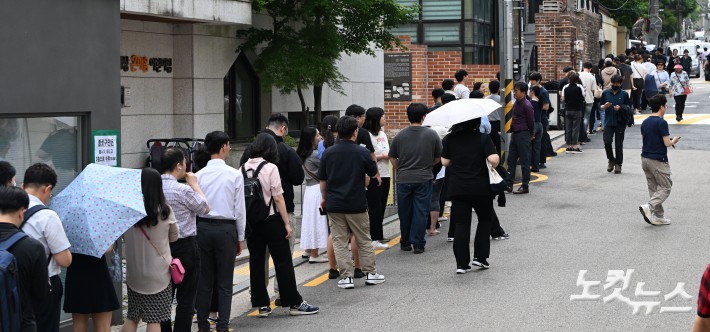 제21대 대통령 선거 사전 투표 첫날인 29일 오후 서울 종로구 사직동 주민센터에 마련된 사전투표소에서 유권자들이 투표를 하기 위해 길게 줄을 서고 있다. 오후 5시 현재 전국 평균 투표율은 역대 최고 수준인 17.51%로 집계됐다.