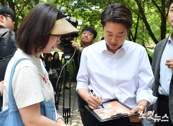 이준석 개혁신당 대선 후보가 30일 서울 마포구 경의선숲 유세에서 유권자에게 사인을 해주고 있다.