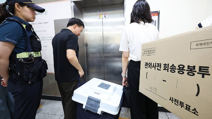 관계자들이 사전투표함과 관외사전회송용 봉투를 보관장소 및 우체국으로 옮기고 있다. 연합뉴스
