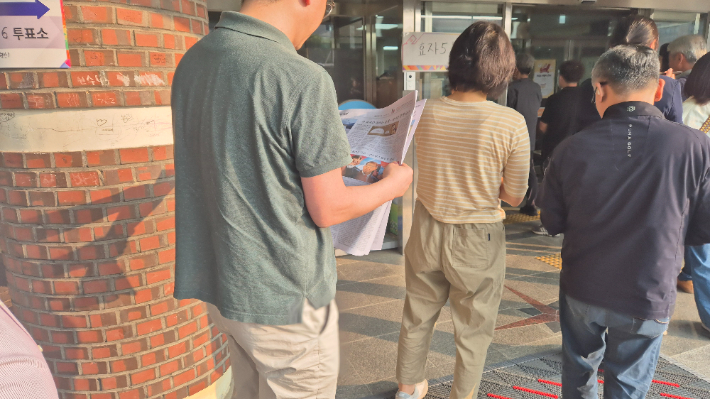 제21대 대선 투표일인 3일 아침, 전북 전주시 완산구 서곡초등학교에 마련된 투표소 앞에서 유권자가 신문을 읽으며 차례를 기다리고 있다. 심동훈 기자