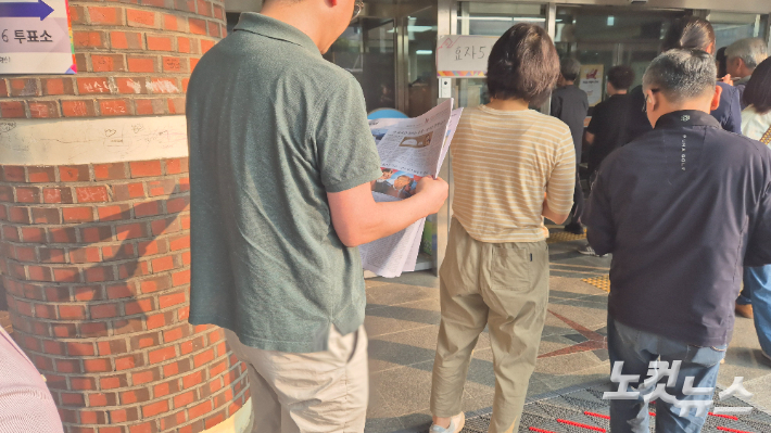 제21대 대선 투표일인 3일 아침, 전북 전주시 완산구 서곡초등학교에 마련된 투표소 앞에서 유권자가 신문을 읽으며 차례를 기다리고 있다. 심동훈 기자